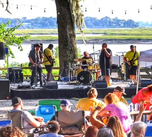 Beers Burgers BBQ . a band playing in front of a body of water