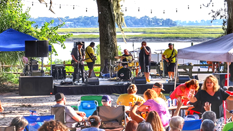 Beers Burgers BBQ . a band playing in front of a body of water